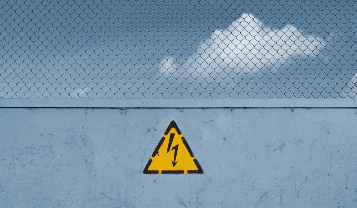 Un cartel de precaución de electrocución publicado en una valla alta